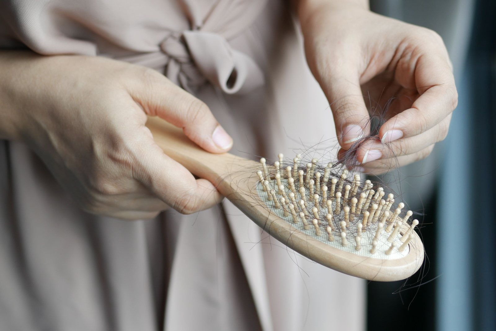 Woman looking at hair left in her hairbrush